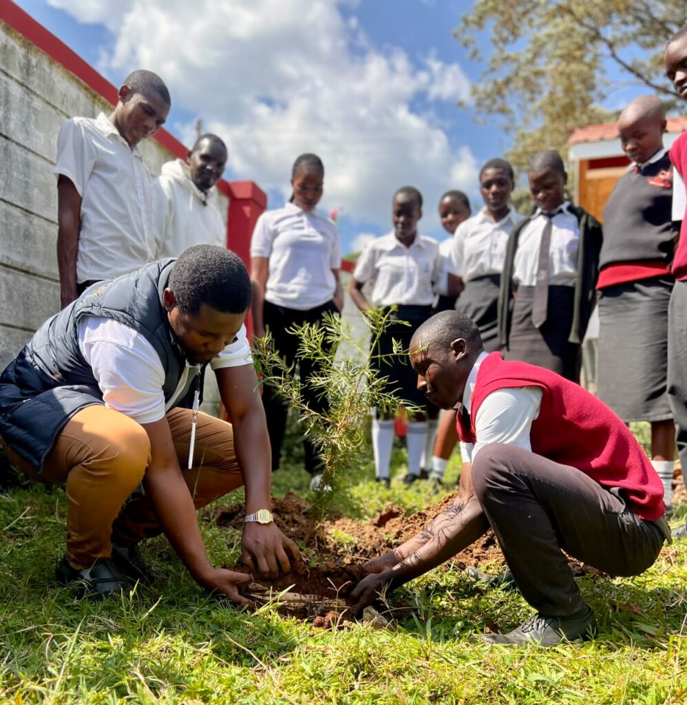Operations Manager at Amaica Media planting a tree at Namagara Senior School